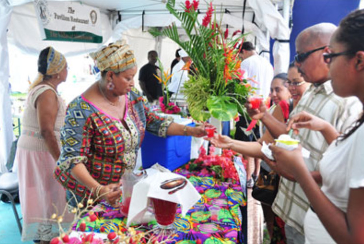 Visitors to the Culinary Festival Tobago where a female presented shows off her miniature dolls to patrons