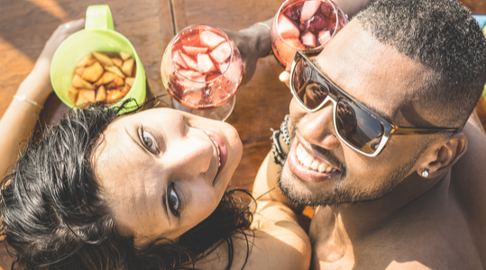 Mixed race couple drinking Caribbean cocktails at the bar