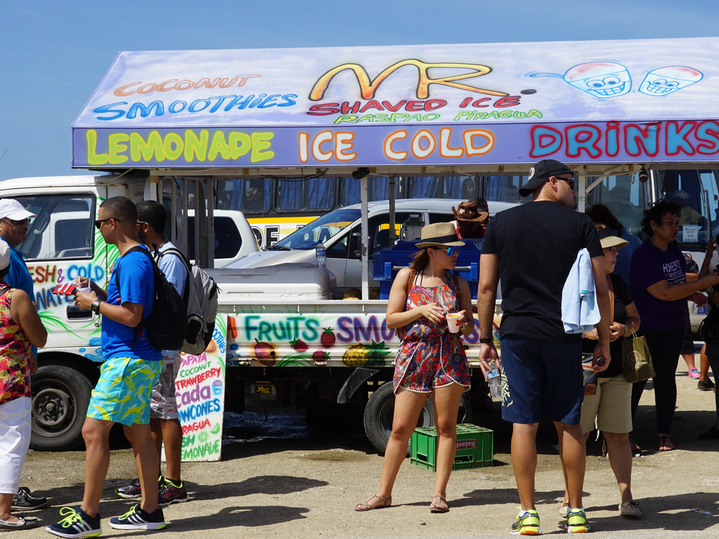 Tourists purchasing cold drinks, fruits and smoothies and a roadside lorry vendor