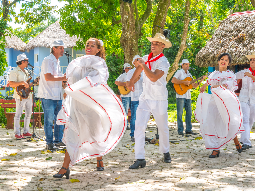 Dancers in costumes and musicians perform traditional Cuban folk dance.