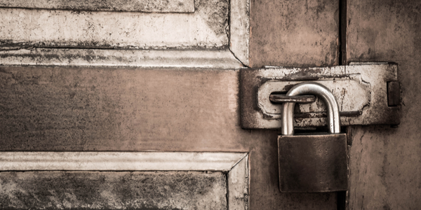 Locked padlock on door signaling a major concern of access when considering AirBnB vs Hotel